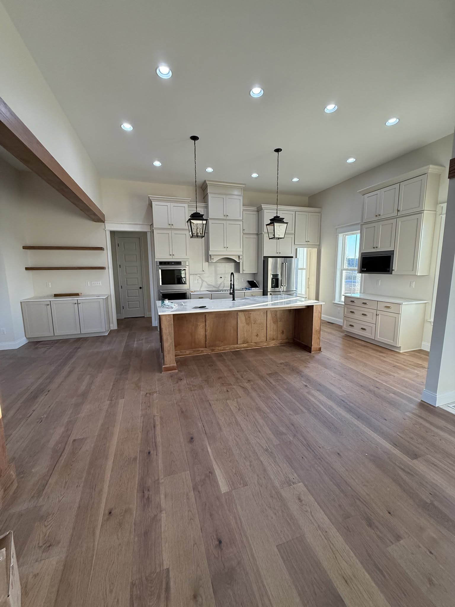 Open kitchen with tall cabinets, vaulted ceiling, and pendant lighting